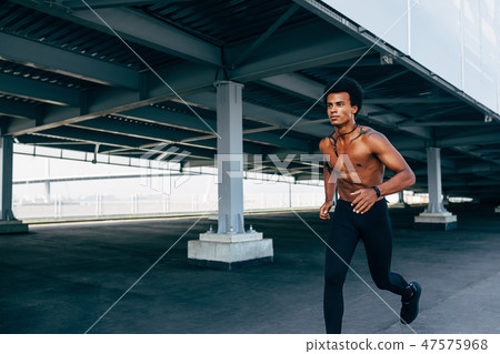Bare chested sportsman running at bridge outdoors 47575968