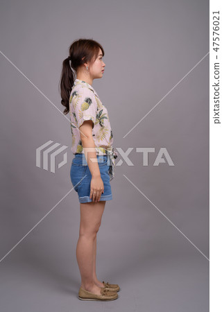 Full length portrait of beautiful young Asian woman standing 47576021