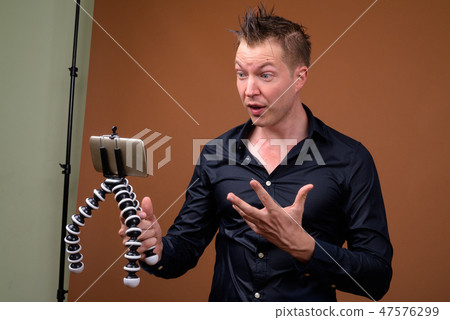 Young man influencer in wet clothes vlogging with mobile phone Young man influencer in wet clothes vlogging with mobile phone 47576299