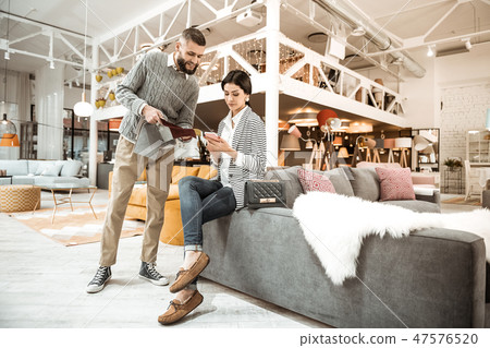 Bearded man in grey sweater displaying interested sample 47576520