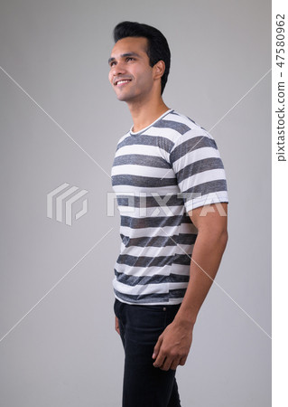 Profile view of happy young handsome Indian man thinking 47580962