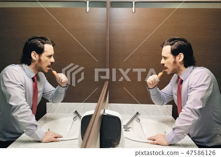 Business Man Brushing Teeth After Lunch Break In Office Bathroom Business Man Brushing Teeth After Lunch Break In Office Bathroom 47586126