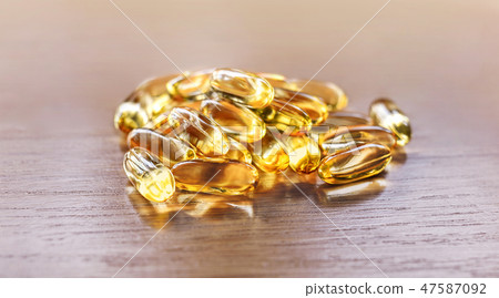 fish oil capsules on wooden table 47587092