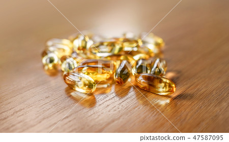 fish oil capsules on wooden table 47587095