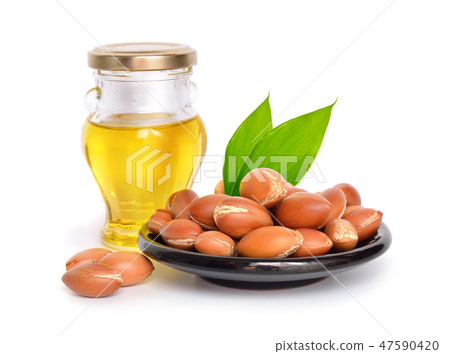 Argan seed with oil. Isolated. 47590420