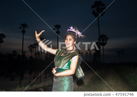 The lady in Thai dancing suit at sugar palm. 47591746