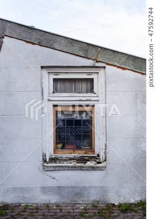 Wall with an old rotten wooden window Wall with an old rotten wooden window 47592744