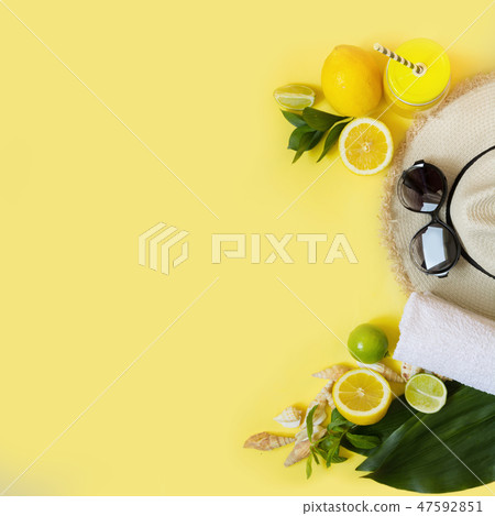Beach accessory with citrics water on yellow.  47592851