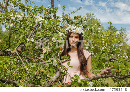 Smiling woman in spring flowers garden outdoors Smiling woman in spring flowers garden outdoors 47595348