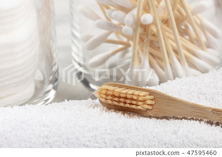 An organic biodegradable bamboo toothbrush with bamboo cotton swabs in the blurred background 47595460