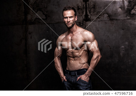 strong athletic man on dark grunge background 47596716