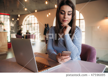 Business lady sitting in cafe and working on a laptop and using phone 47596895