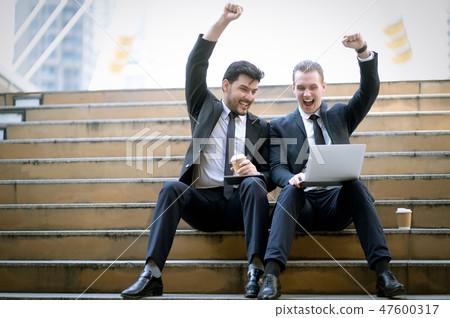 Two cheerful business man sitting stairs celebrate Two cheerful business man sitting stairs celebrate 47600317