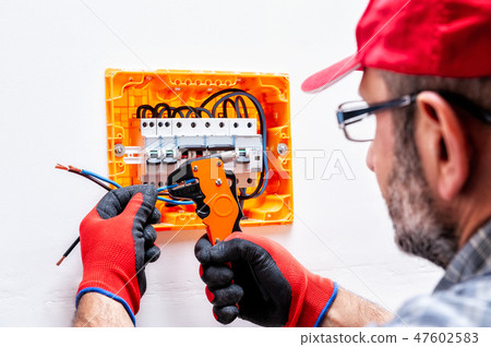 Electrician at work on an electrical panel. Electrician at work on an electrical panel. 47602583