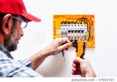 Electrician at work on an electrical panel. 47602587