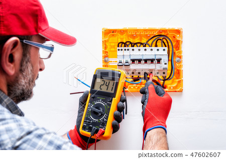 Electrician at work on an electrical panel. Electrician at work on an electrical panel. 47602607