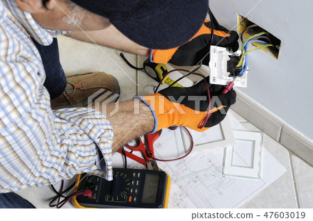 Electrician working in a residential electrical system Electrician working in a residential electrical system 47603019