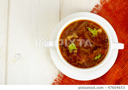 Soup with vegetables on white wooden surface 47604653