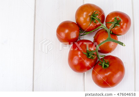 Branch of red tomatoes on white boards 47604658