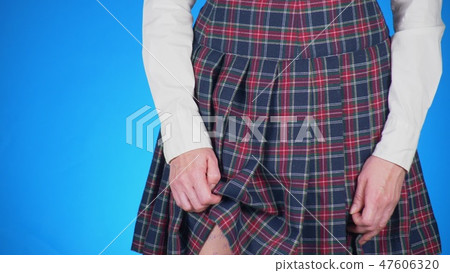Midsection of teenage girl, cheat sheet written on hips hidden under a skirt. close-up, blue 47606320