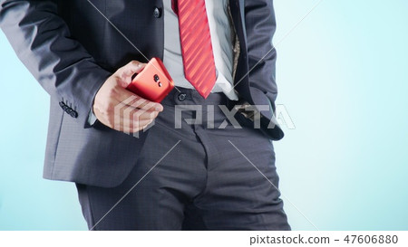 Colorful background. Close-up. Thighs of a man. businessmen in red tie uses red smartphone. 47606880