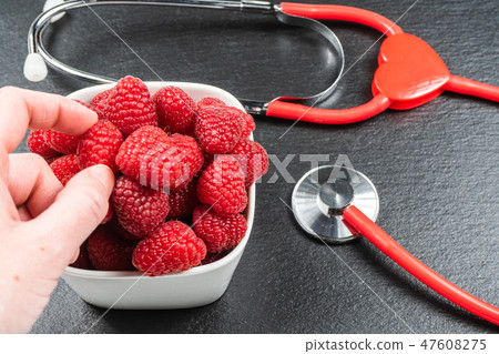 Plate with raspberry on black stone background. Plate with raspberry on black stone background. 47608275