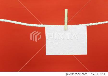 Empty note paper hang on the clothesline and have copy space with red background. 47611451