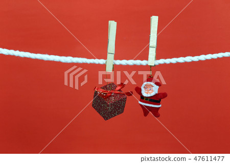 Santa doll hang on the clothesline and have copy space with red background. Santa doll hang on the clothesline and have copy space with red background. 47611477