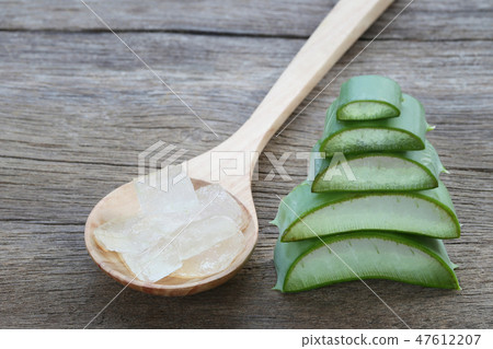 Sliced fresh Aloe Vera in wooden spoon on brown wood floor. 47612207