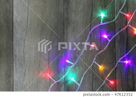 Colorful of Christmas lights on brown wooden floor. 47612352
