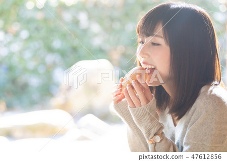 A young woman eating a snack 47612856