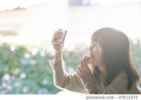 A young woman eating a snack 47612878
