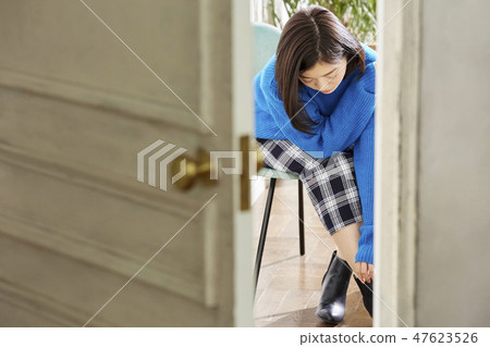 A woman getting dressed. 47623526