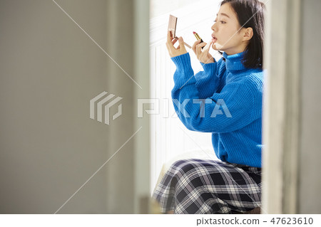 Woman doing make-up Woman doing make-up 47623610