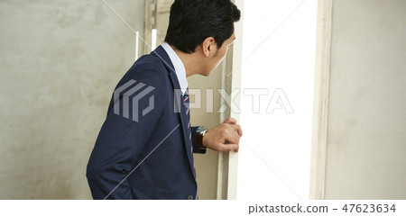 A businessman opening a door 47623634
