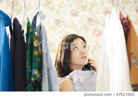 A woman getting dressed. 47623803