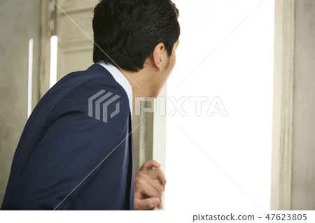 A businessman opening a door 47623805