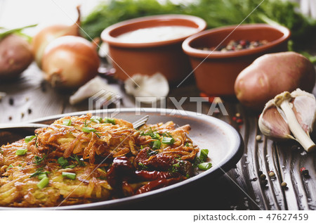Homemade tasty potato pancakes in clay dish 47627459