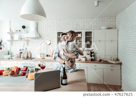 Handsome dark-haired smiling man in a checkered shirt and his beautiful wife feeling wonderful 47627625