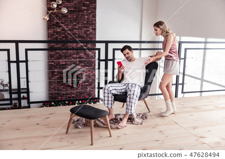 Dark-haired bearded young man in a white t-shirt and his wife looking expressive 47628494