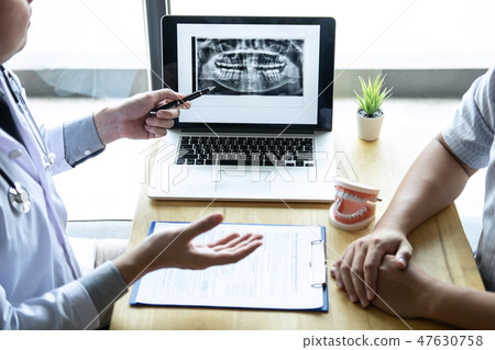 Image of doctor or dentist presenting with tooth x-ray film reco 47630758