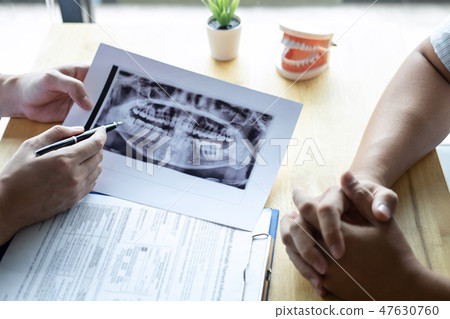 Image of doctor or dentist presenting with tooth x-ray film reco 47630760