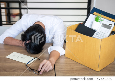 Stressed businessman will being resignation and packing belongin Stressed businessman will being resignation and packing belongin 47630880