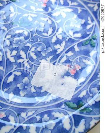 A price tag seal on a dish that can not be cleaned cleanly A price tag seal on a dish that can not be cleaned cleanly 47630977