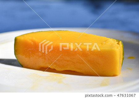 Cut juicy mango fruit in a plate on the beach 47631067