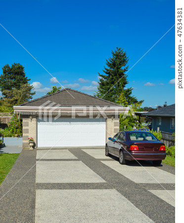 Passenger car parked on bar colored concrete driveway at the garage. Passenger car parked on bar colored concrete driveway at the garage. 47634381