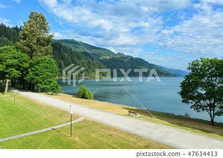 View on Harrison lake and mountains with walk way along the shore in front View on Harrison lake and mountains with walk way along the shore in front 47634413