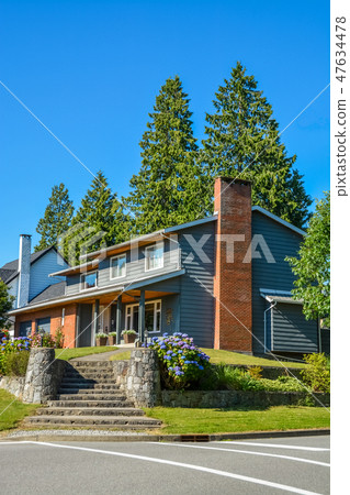 Big residential house with steps leading to front yard on land terrace Big residential house with steps leading to front yard on land terrace 47634478