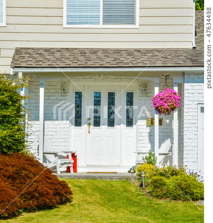 Entrance of the house with backet of flowers, two white chairs, and red churn Entrance of the house with backet of flowers, two white chairs, and red churn 47634498
