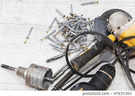 hammer drill and dowels on the wooden background 47635363